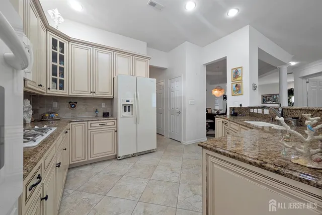 a kitchen with stainless steel appliances granite countertop a stove refrigerator and cabinets