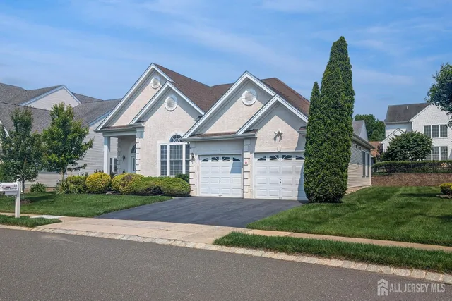 a front view of a house with a garden and plants