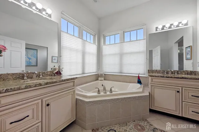 a bathroom with a tub sink and mirror