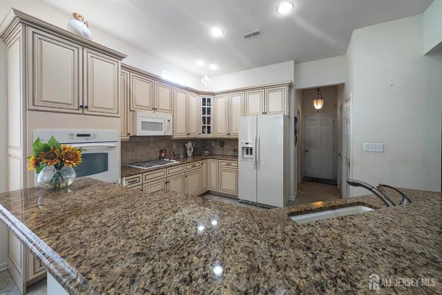 a kitchen with stainless steel appliances granite countertop a stove a sink and a refrigerator