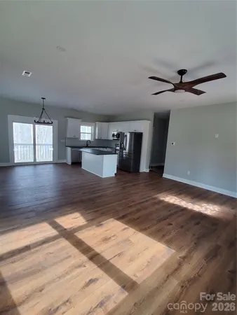 a kitchen with stainless steel appliances granite countertop a refrigerator a sink dishwasher a stove and a large refrigerator