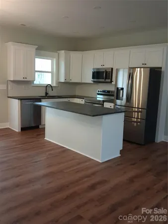a kitchen with stainless steel appliances a refrigerator and a stove top oven