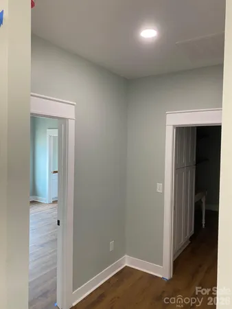 an empty room with wooden floor chandelier fan and windows