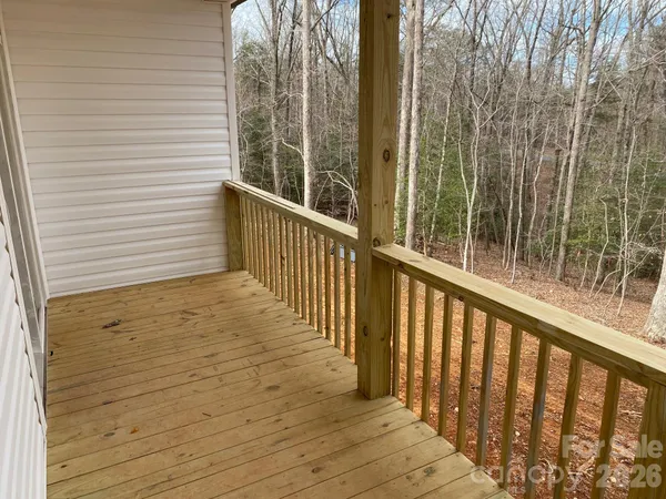 a view of balcony with wooden floor and fence