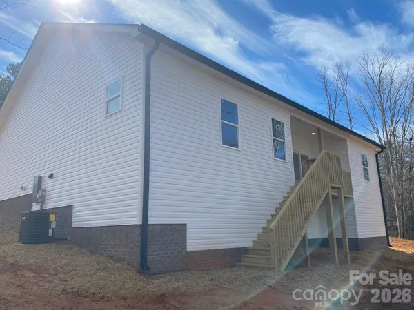 a front view of house with yard and trees in the background