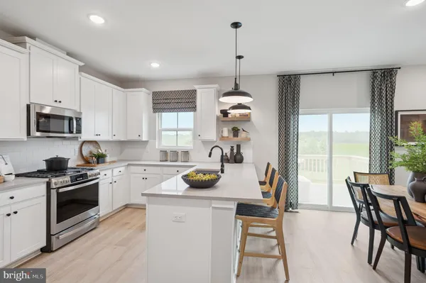 a kitchen with a stove a refrigerator and a wooden floor