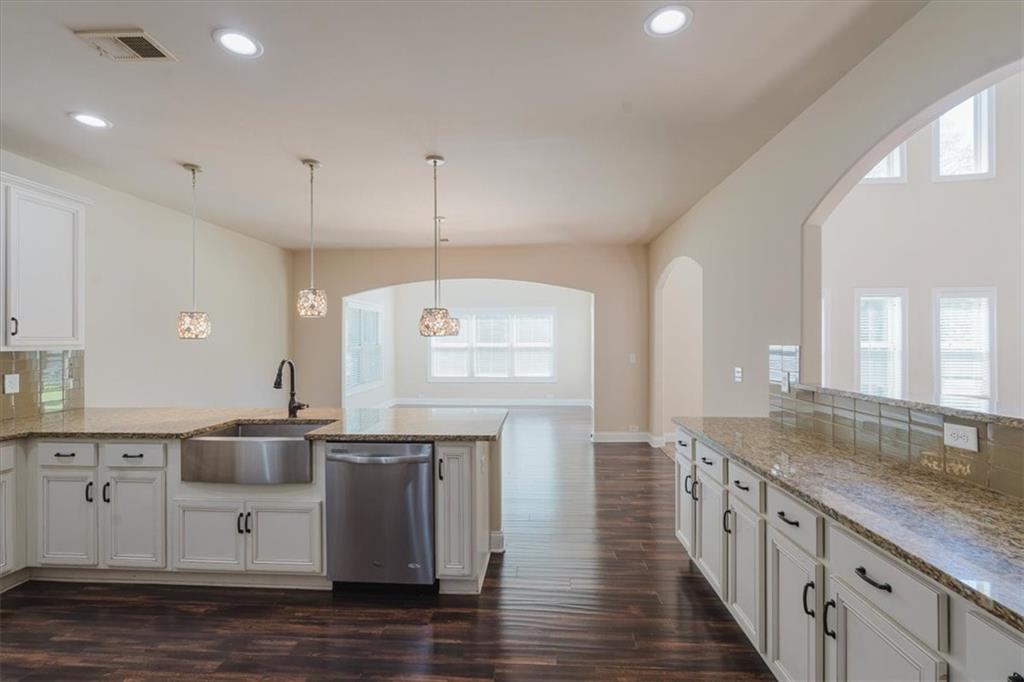 2368 Beringer Lane Powder Springs, GA 30127 - Photo 12 of 59 a kitchen with stainless steel appliances granite countertop a sink a stove and a wooden floors