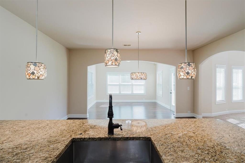 2368 Beringer Lane Powder Springs, GA 30127 - Photo 15 of 59 a view of a kitchen with kitchen island a sink wooden floor and a living room view