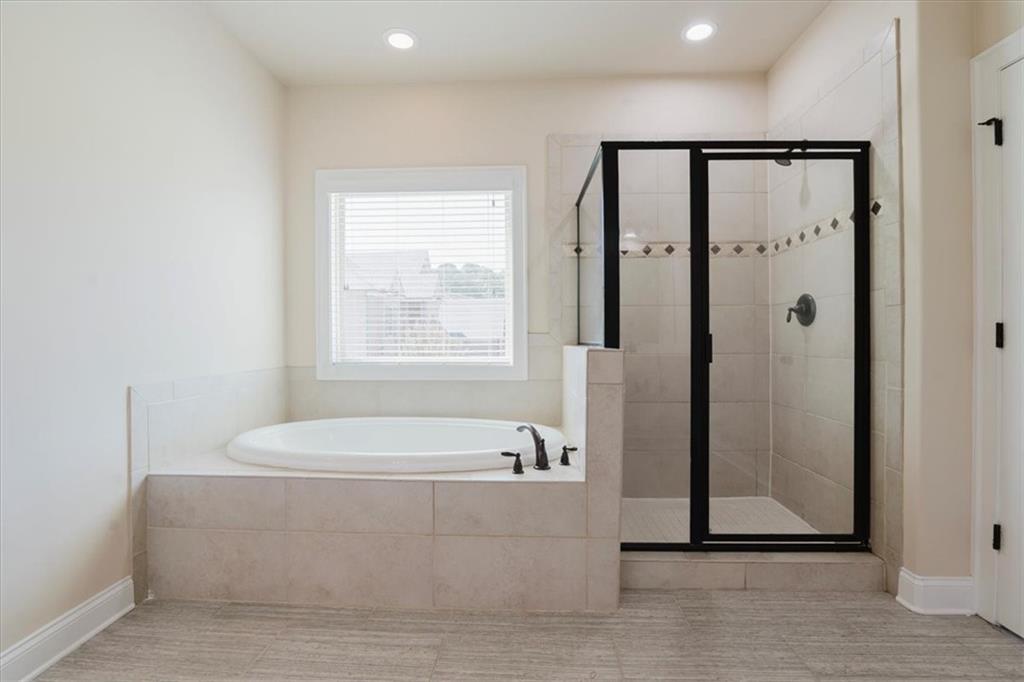 2368 Beringer Lane Powder Springs, GA 30127 - Photo 33 of 59 a bathroom with a bathtub and a shower