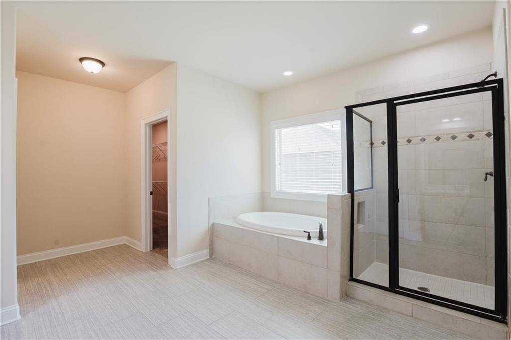 2368 Beringer Lane Powder Springs, GA 30127 - Photo 36 of 59 a bathroom with a bathtub and a shower