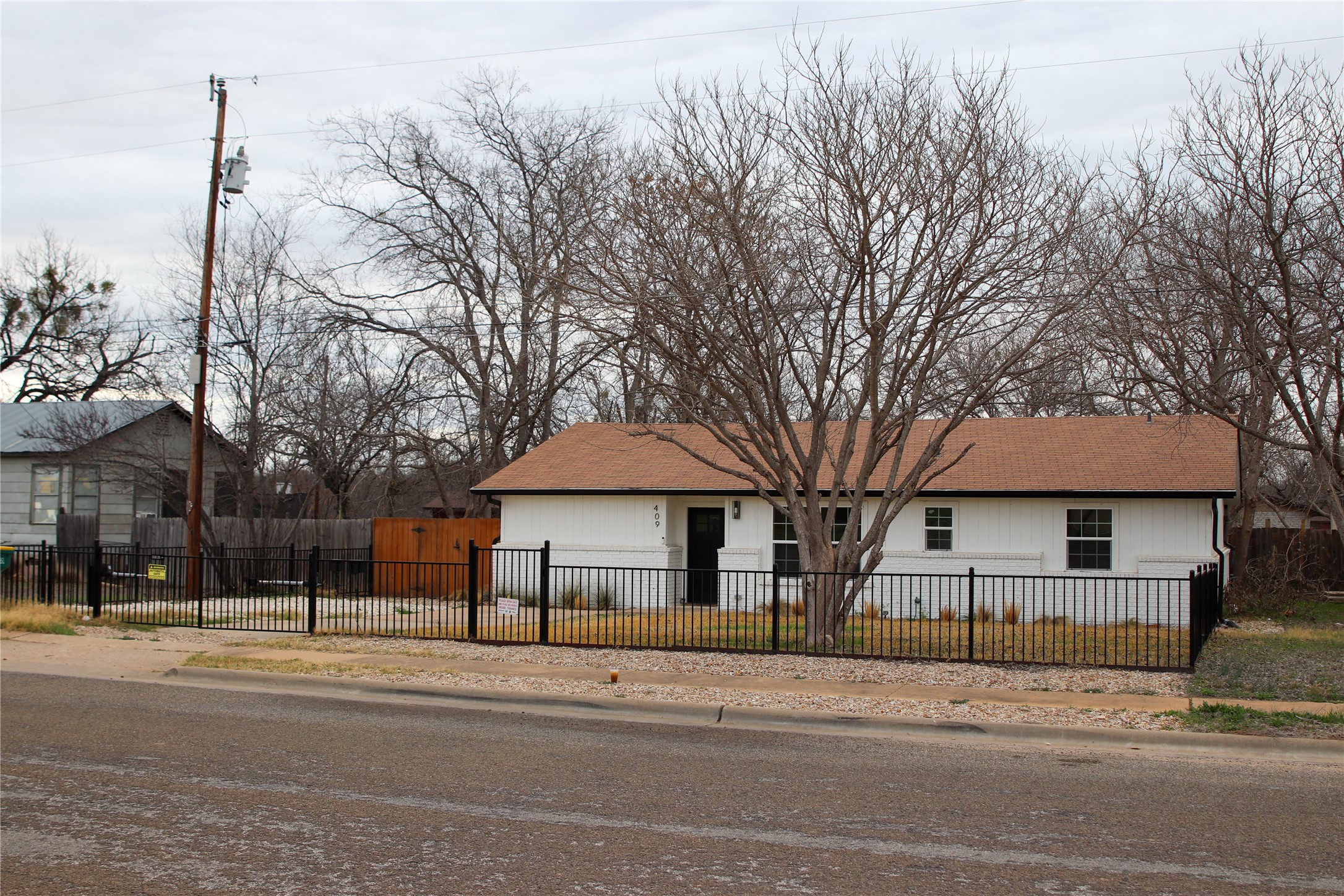 409 Ave R Marble Falls, TX 78654 - Photo 4 of 25 Photo taken in winter White exterior with a brown shingle roof