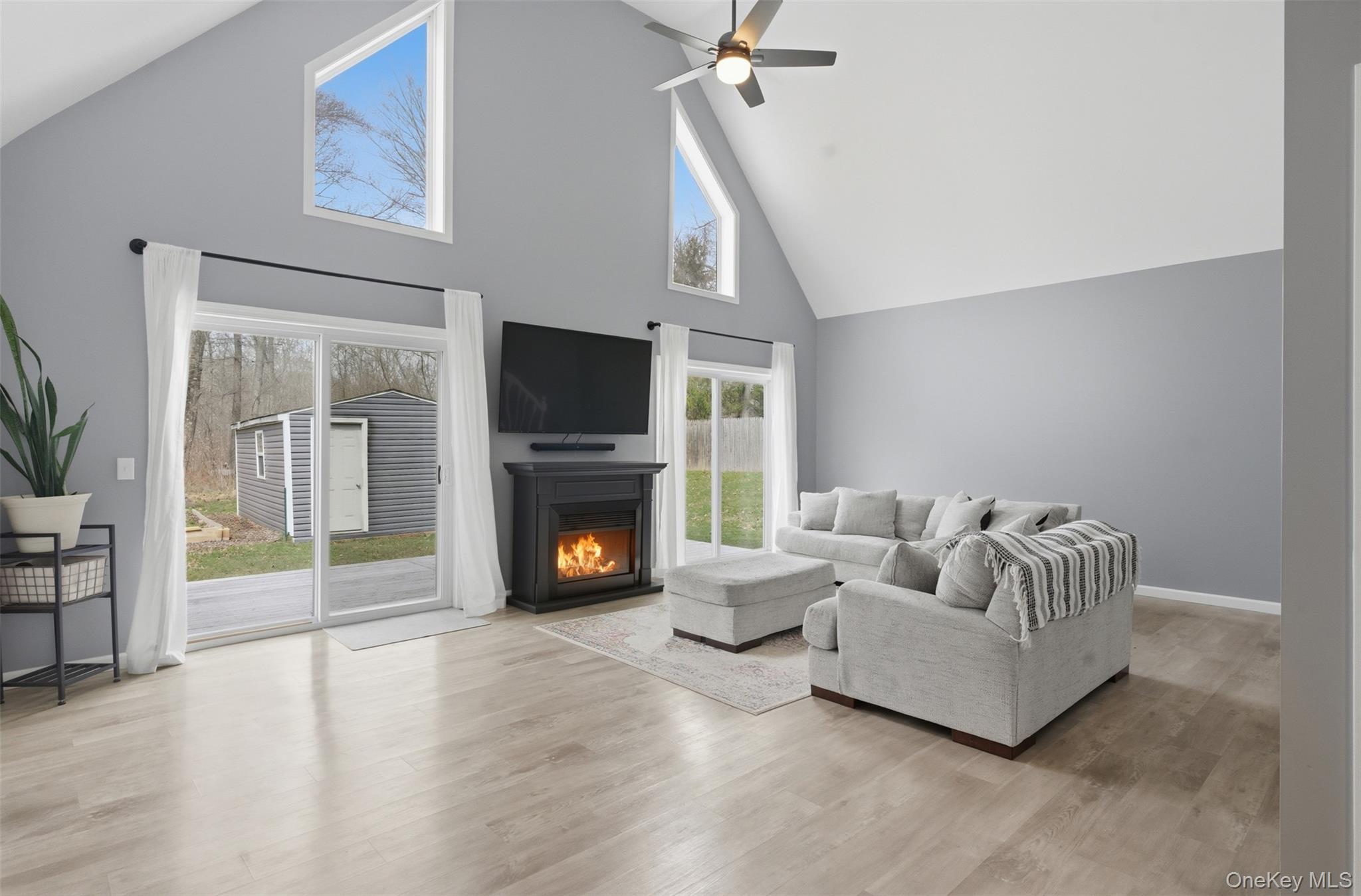 1227 Burlingham Road Pine Bush, NY 12566 - Photo 8 of 39 Living room with a ceiling fan, a high ceiling, light wood finished floors, and an electric fireplace