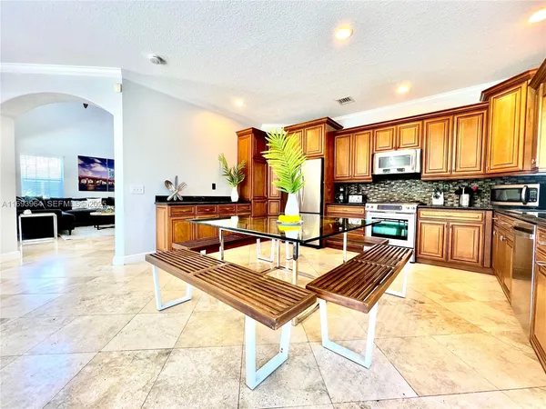 a living room with stainless steel appliances kitchen island granite countertop a kitchen view and living room furniture