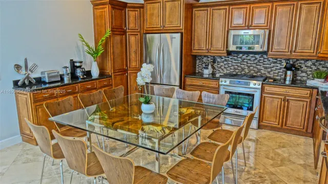 a kitchen with stainless steel appliances granite countertop a sink and a refrigerator