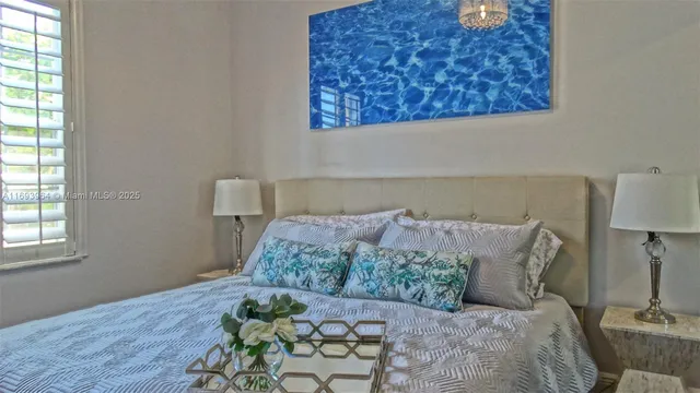 a bed sitting in a bedroom next to a window with lamp