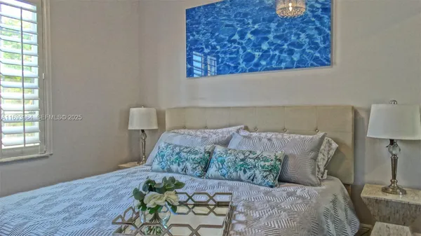 a bed sitting in a bedroom next to a window with lamp