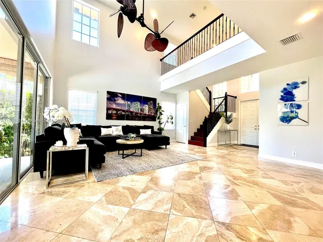 a living room with furniture entryway and a flat screen tv
