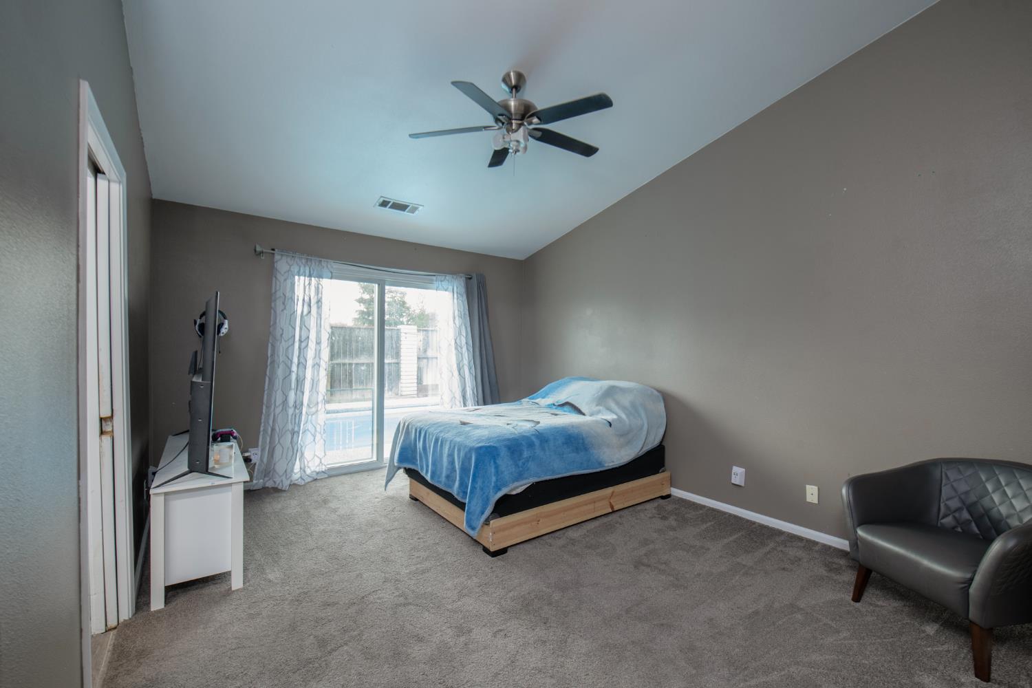 338 North Filbert Avenue Clovis, CA 93611 - Photo 16 of 33 a spacious bedroom with a bed and a couch