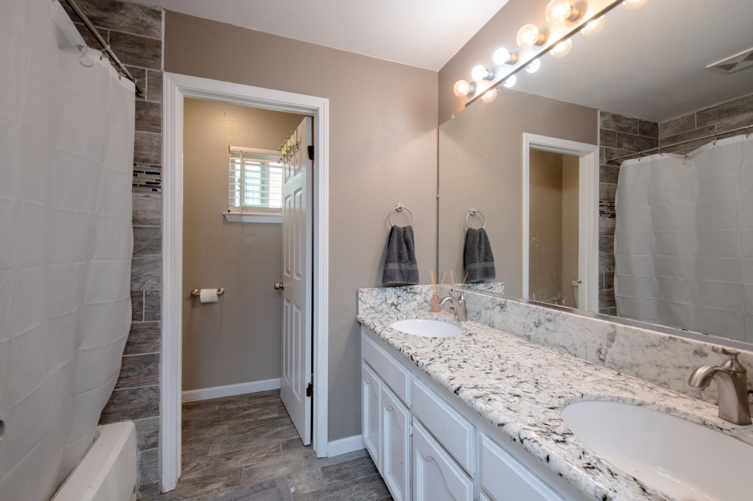 338 North Filbert Avenue Clovis, CA 93611 - Photo 24 of 33 a bathroom with a granite countertop sink and a mirror