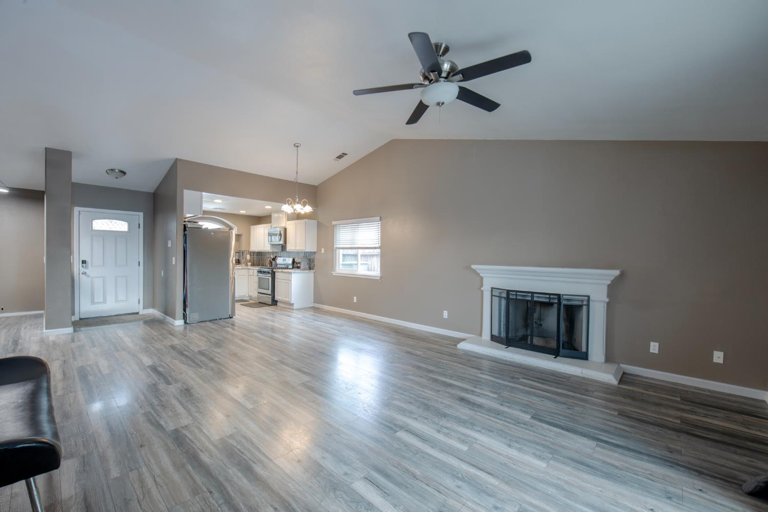 338 North Filbert Avenue Clovis, CA 93611 - Photo 10 of 33 an empty room with wooden floor a ceiling fan and windows