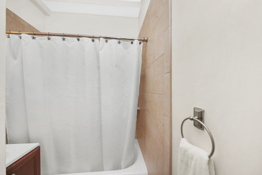 21 Beacon Street, Unit 6F Boston, MA 02108 - Photo 12 of 16 a bathroom with a shower curtain and a sink