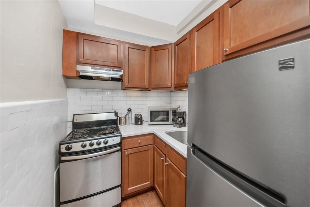 21 Beacon Street, Unit 6F Boston, MA 02108 - Photo 7 of 16 a kitchen with a stove and a microwave