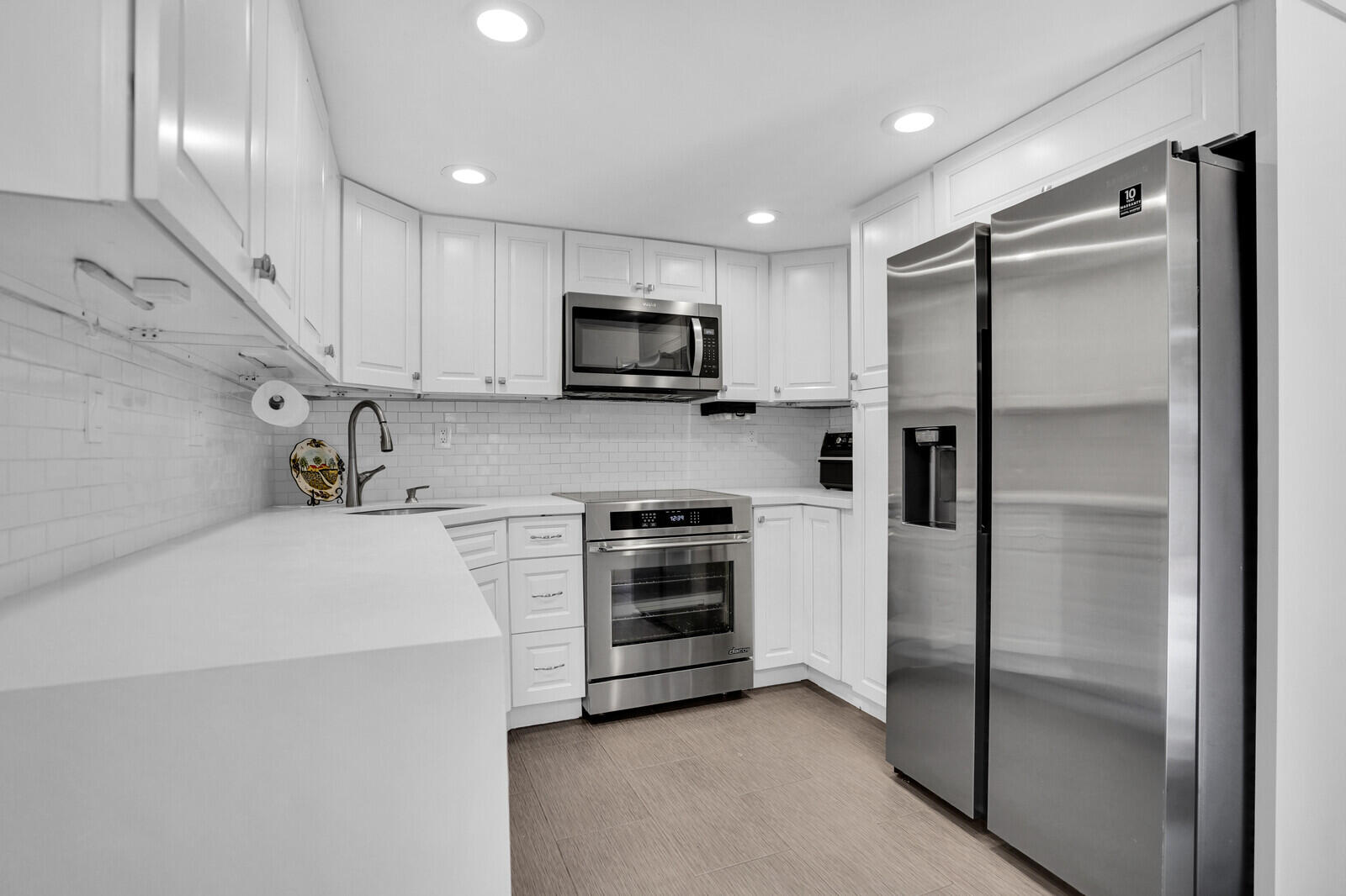 8291 Thames Boulevard, Unit C Boca Raton, FL 33433 - Photo 2 of 20 a kitchen with stainless steel appliances a refrigerator sink and microwave