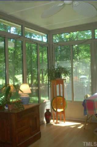 Relax in the sunroom facing the privacy of the back wooded lot