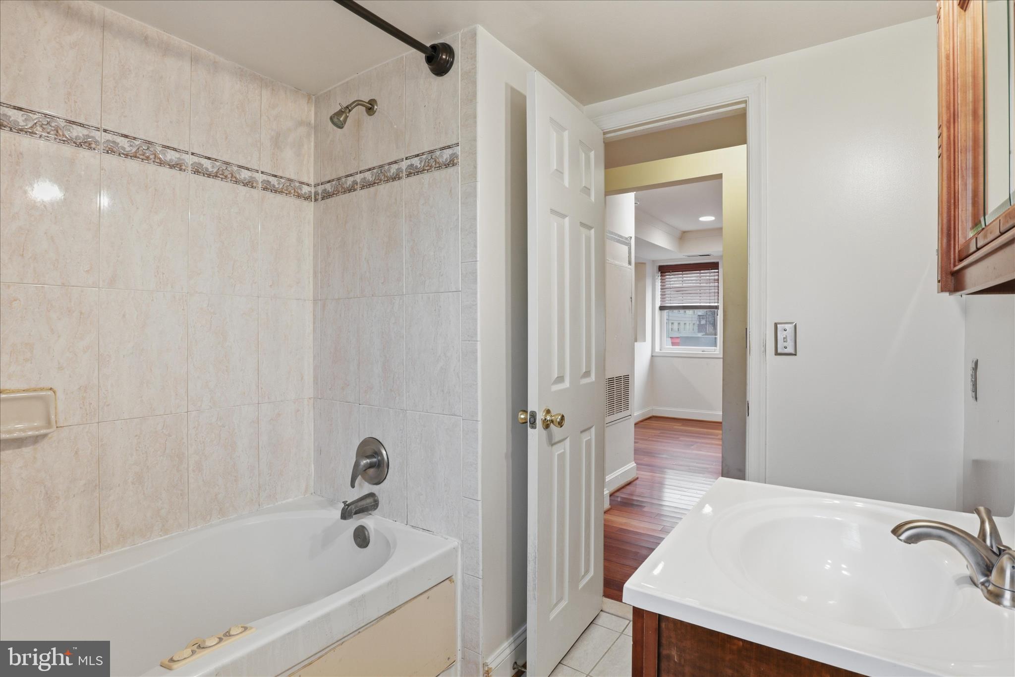 3866 9th Street Southeast, Unit 102 Washington, DC 20032 - Photo 13 of 21 a bathroom with a tub a sink and a shower