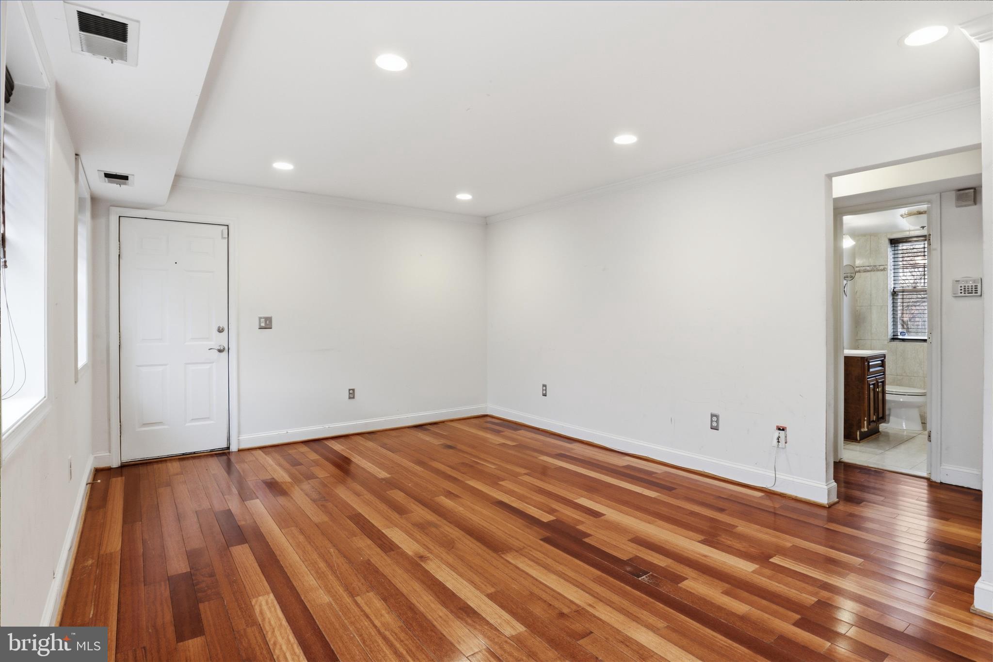3866 9th Street Southeast, Unit 102 Washington, DC 20032 - Photo 8 of 21 an empty room with wooden floor and windows