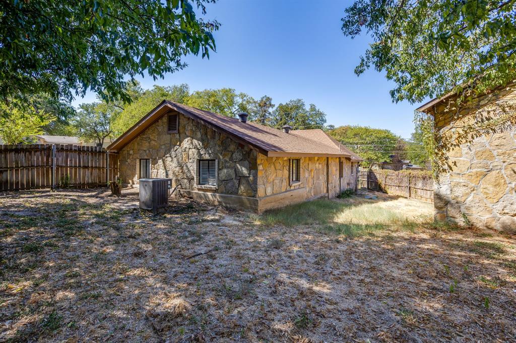 6940 Hatch Road Fort Worth, TX 76135 - Photo 40 of 40 Stone exterior with a shingle roof and multiple windows