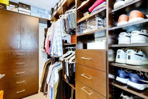 a view of walk in closet with clothes and shoes