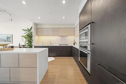 a large kitchen with stainless steel appliances a large counter top a stove and a refrigerator