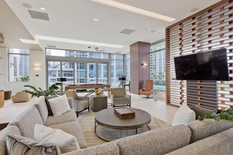 a dining hall with stainless steel appliances kitchen island a table and chairs in it
