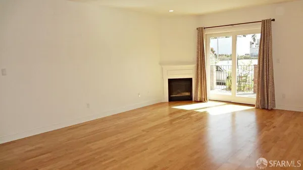 a view of an empty room with a window and fireplace