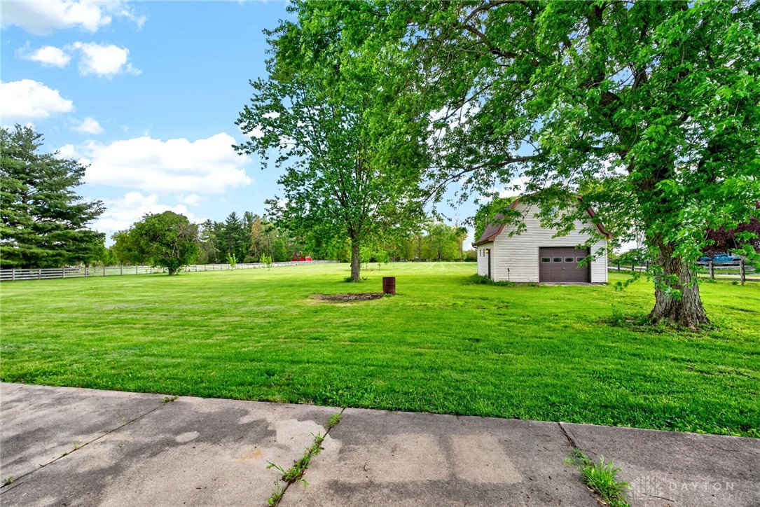 1005 Free Road New Carlisle, OH 45344 - Photo 38 of 43 Expansive green grounds feature a standalone garage, offering ample space and serene outdoor living.