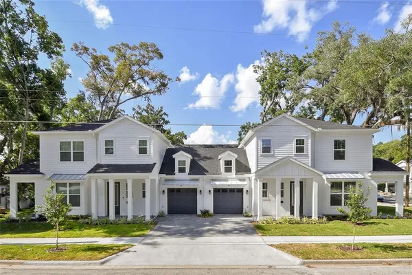 a front view of a house with a yard and trees