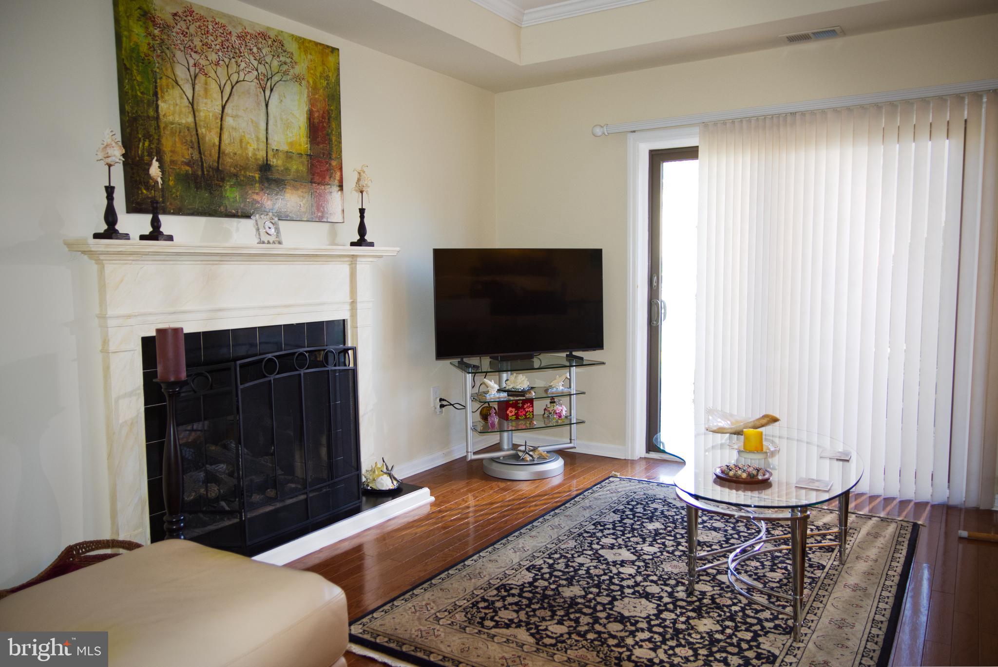 5 Greate Bay Drive Somers Point, NJ 08244 - Photo 6 of 62 a living room with furniture a flat screen tv and a fireplace
