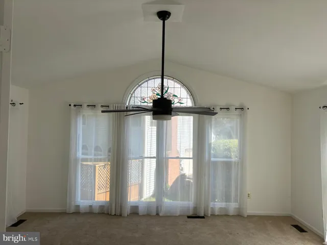 a living room with hardwood floor and a ceiling fan