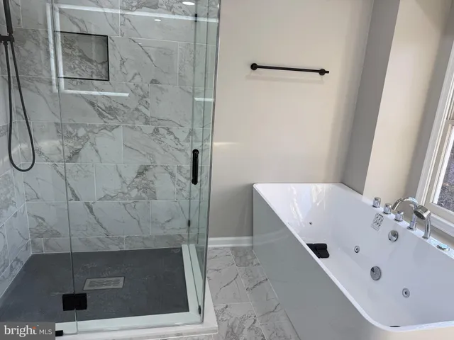 a bathroom with a bathtub and shower