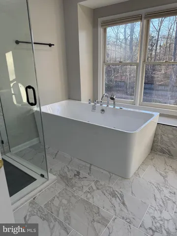 a spacious bathroom with a bathtub and shower