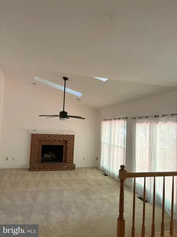 a view of an empty room with a fireplace and a window