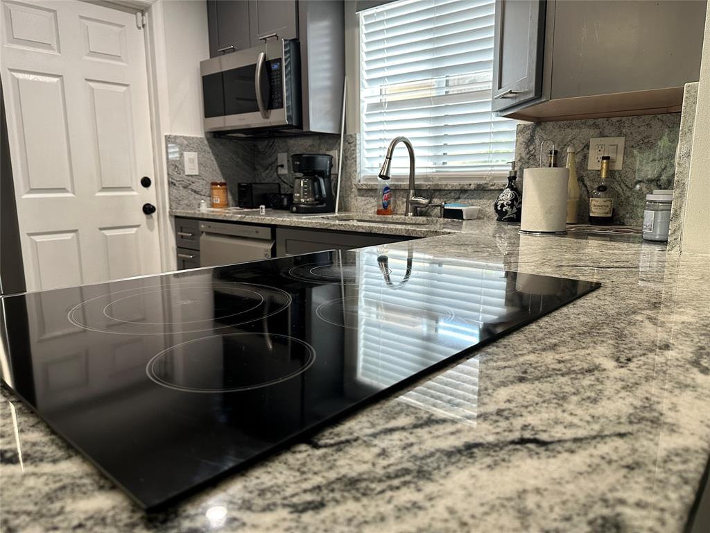 8121 Southwest 8th Street North Lauderdale, FL 33068 - Photo 2 of 16 a kitchen with granite countertop a sink a stove and cabinets