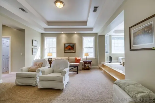 a bedroom with a bed couch and a large window