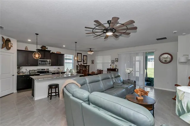 a kitchen with stainless steel appliances granite countertop a stove a sink dishwasher a dining table and chairs with wooden floor