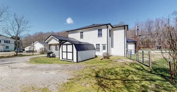a view of a house with a yard and pathway