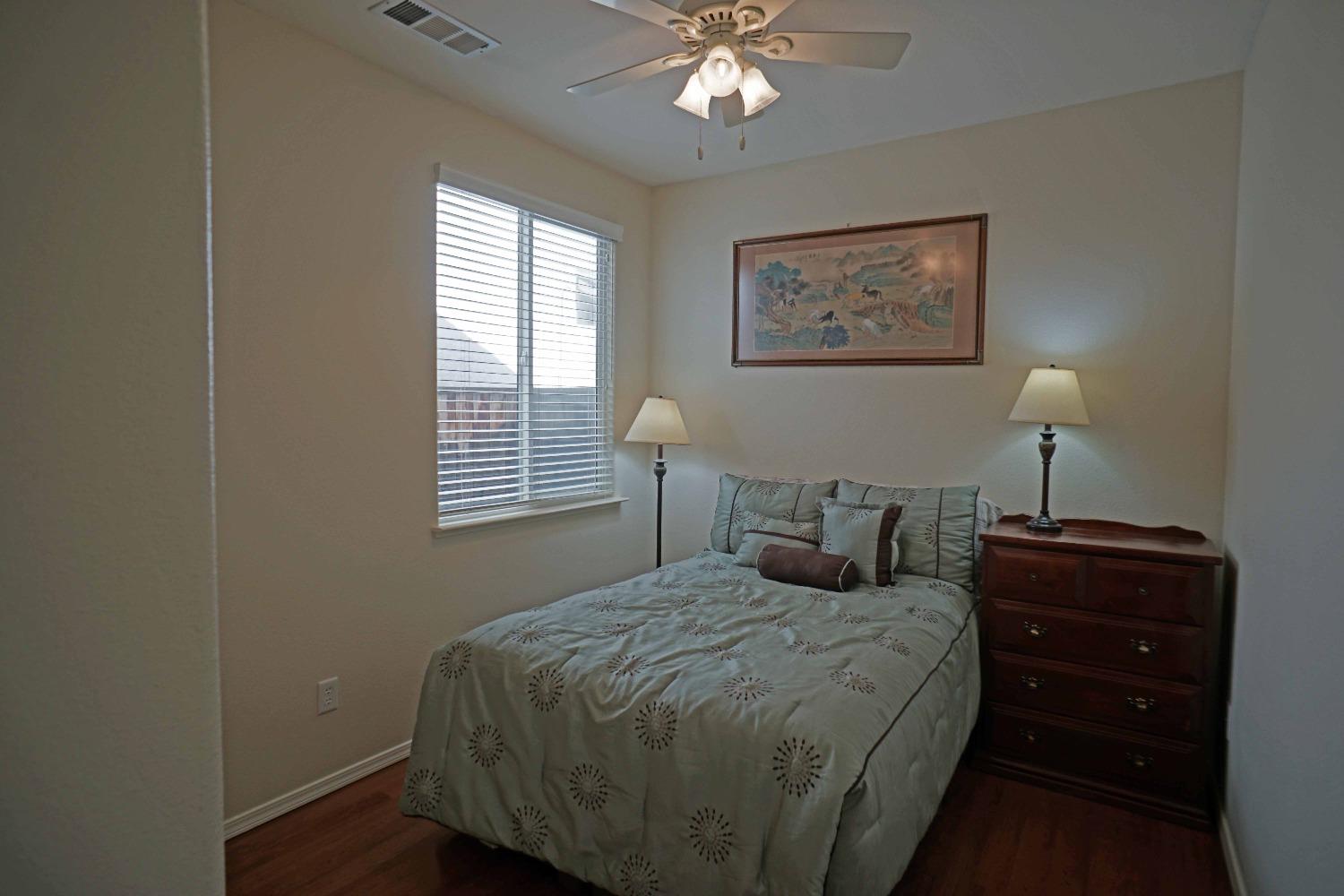 618 West Lisbon Lane Clovis, CA 93619 - Photo 12 of 26 a bedroom with a bed and a lamp on dresser