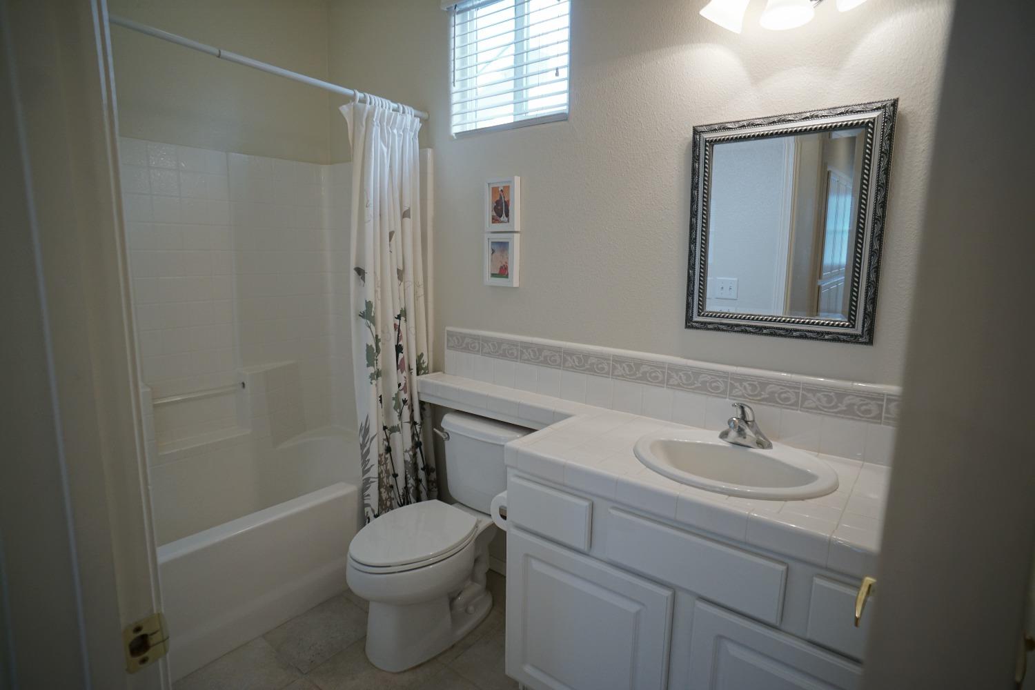 618 West Lisbon Lane Clovis, CA 93619 - Photo 14 of 26 a bathroom with a sink a toilet and shower