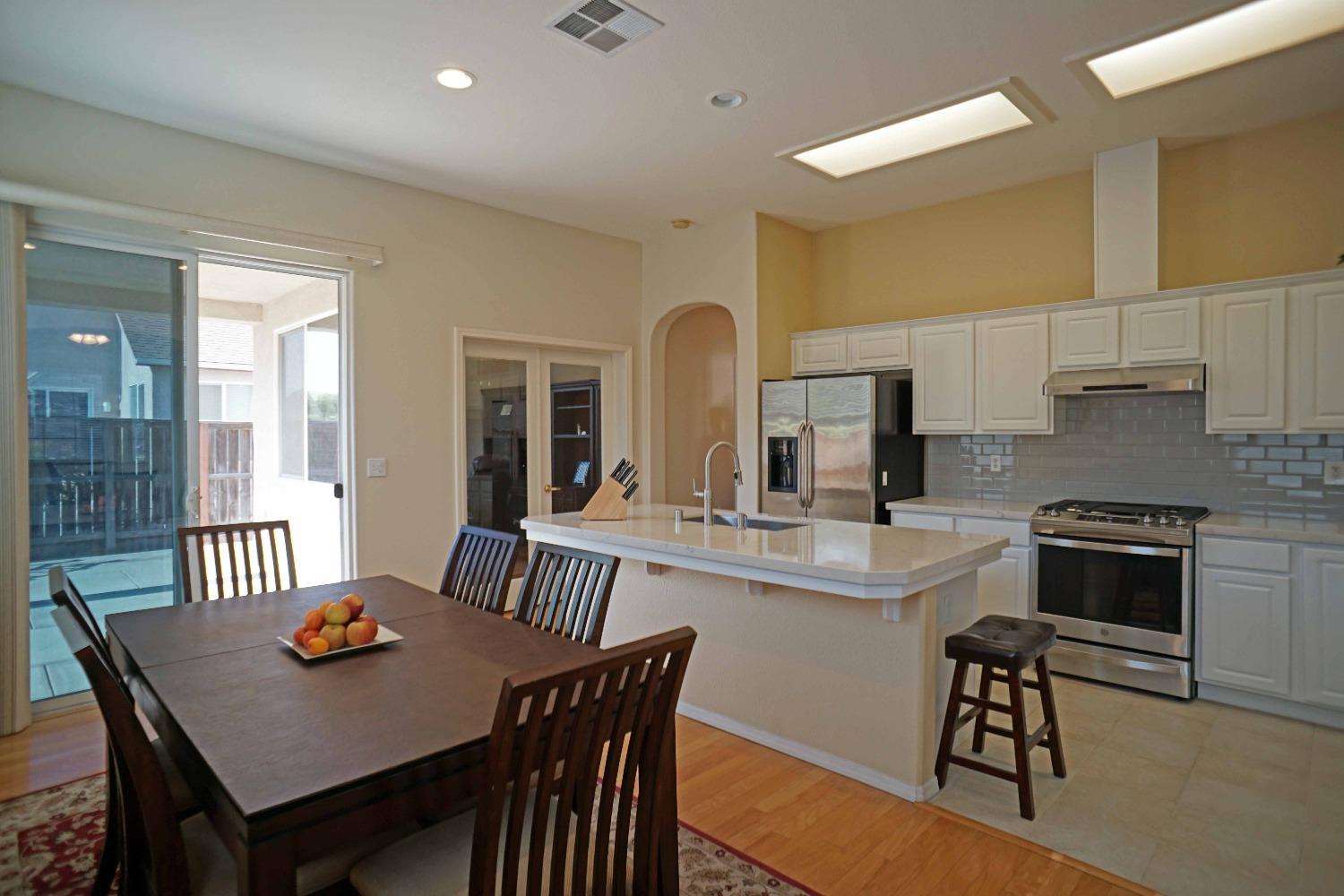 618 West Lisbon Lane Clovis, CA 93619 - Photo 5 of 26 a kitchen with stainless steel appliances kitchen island granite countertop a dining table and chairs