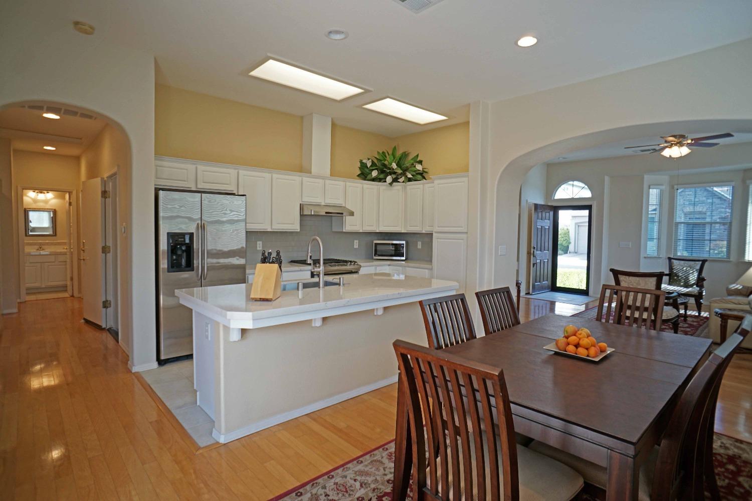 618 West Lisbon Lane Clovis, CA 93619 - Photo 8 of 26 a kitchen with a dining table chairs and white cabinets